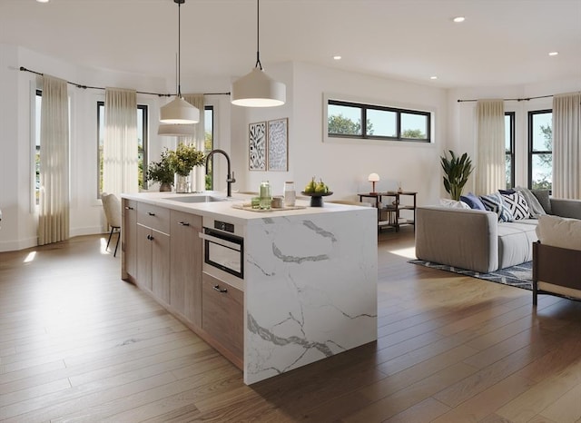 33 Pearl St Unit B, Boston, MA 02125 - kitchen featuring light wood finished floors, a center island with sink, open floor plan, hanging light fixtures, and recessed lighting