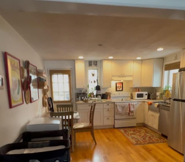 kitchen with stainless steel appliances, light wood-type flooring, and white cabinets