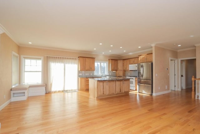 kitchen featuring stone countertops, a center island, light wood-type flooring, white appliances, and backsplash