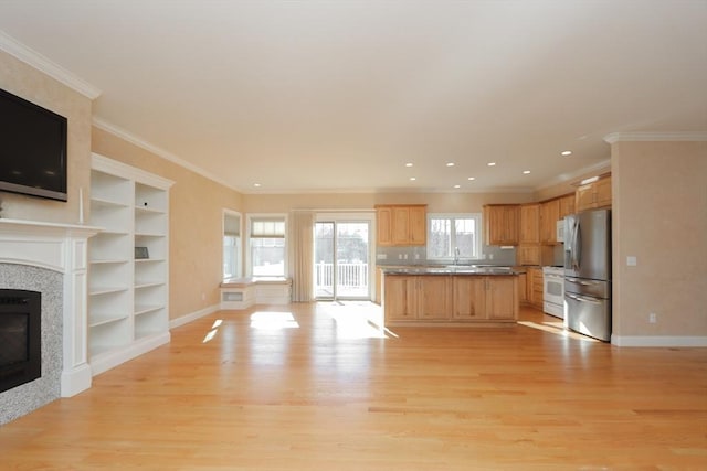 kitchen featuring sink, crown molding, light wood-type flooring, stainless steel refrigerator, and white range