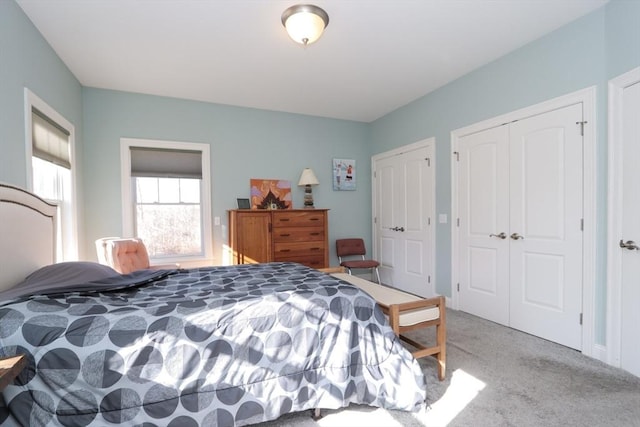 carpeted bedroom featuring multiple closets