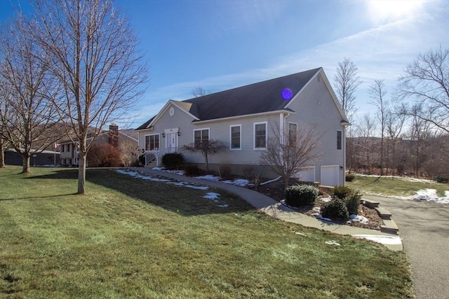 view of side of property featuring a garage and a lawn