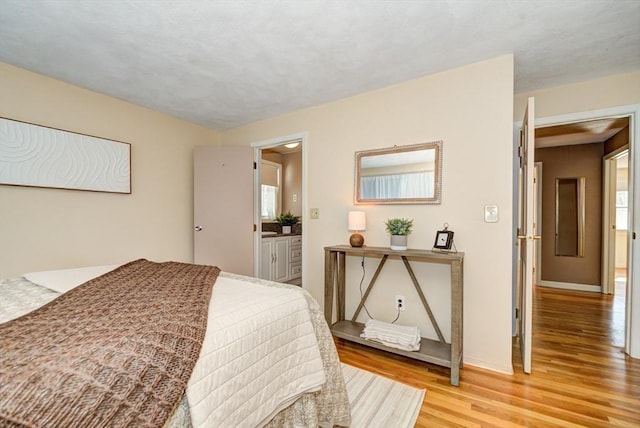 bedroom with light wood-type flooring and baseboards