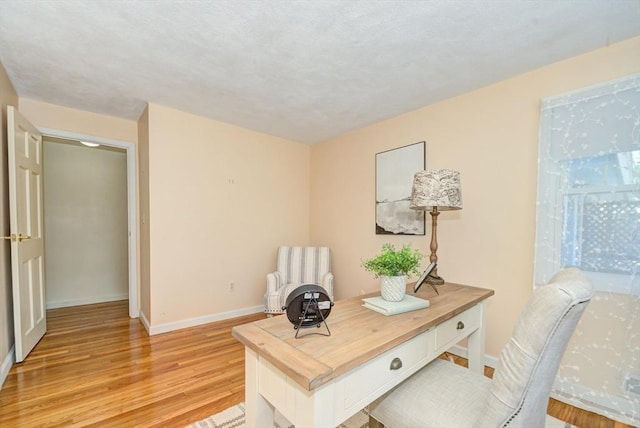 office area featuring baseboards and light wood finished floors