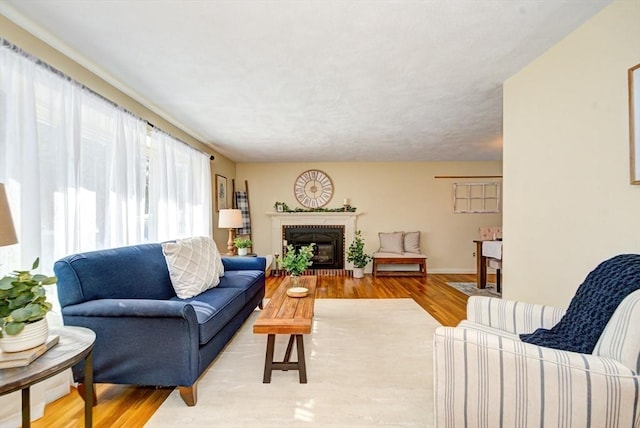 living room featuring light wood finished floors and a brick fireplace