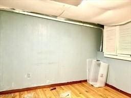 basement featuring baseboards and light wood-style floors