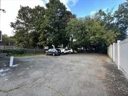 uncovered parking lot featuring fence