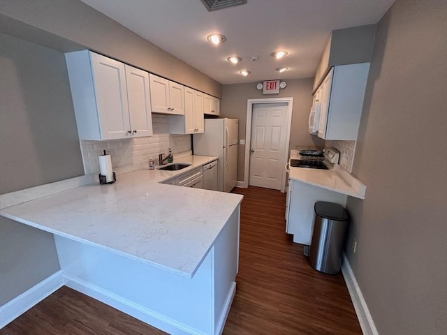 27 Fuller Pond Rd Unit 27, Middleton, MA 01949 - kitchen with a sink, white appliances, a peninsula, baseboards, and decorative backsplash