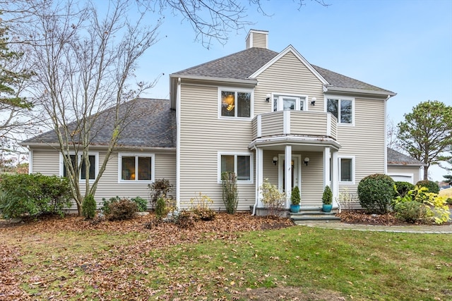 view of front of home with a balcony and a front lawn