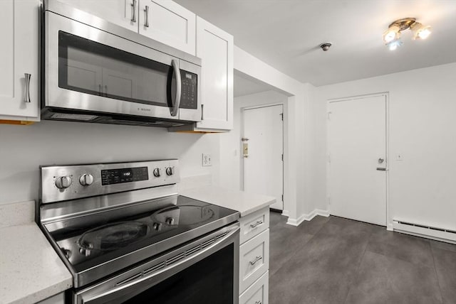 124 Addison St Unit 15, Chelsea, MA 02150 - kitchen with light stone counters, a baseboard radiator, stainless steel appliances, and white cabinetry