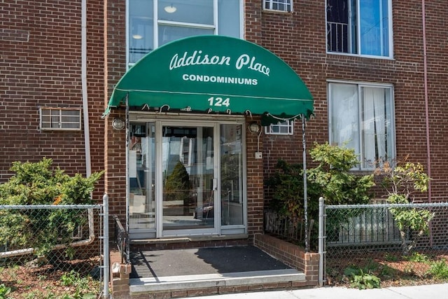 124 Addison St Unit 15, Chelsea, MA 02150 - view of exterior entry with brick siding and fence