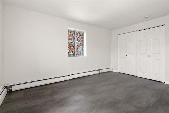 124 Addison St Unit 15, Chelsea, MA 02150 - unfurnished bedroom with a closet, a baseboard radiator, finished concrete flooring, and baseboards