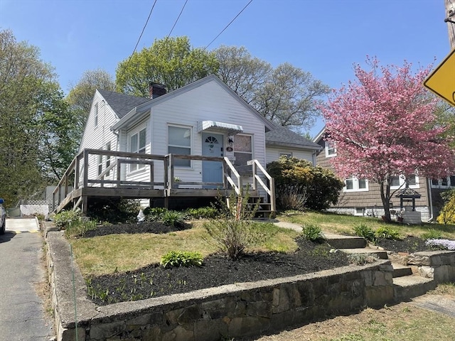 bungalow featuring a chimney, a shingled roof, stairway, and a deck
