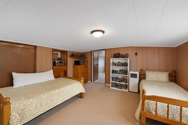 bedroom featuring wooden walls and light carpet