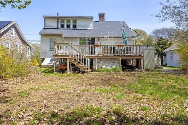 back of house with stairs, roof with shingles, a chimney, and a deck