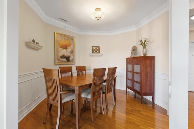 dining room featuring ornamental molding and hardwood / wood-style floors