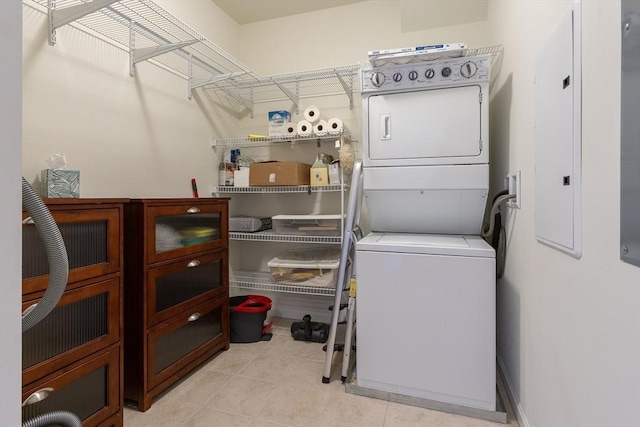 washroom with stacked washer and dryer and light tile patterned flooring