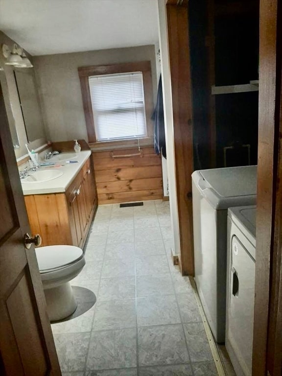 bathroom featuring vanity, washer and clothes dryer, and toilet