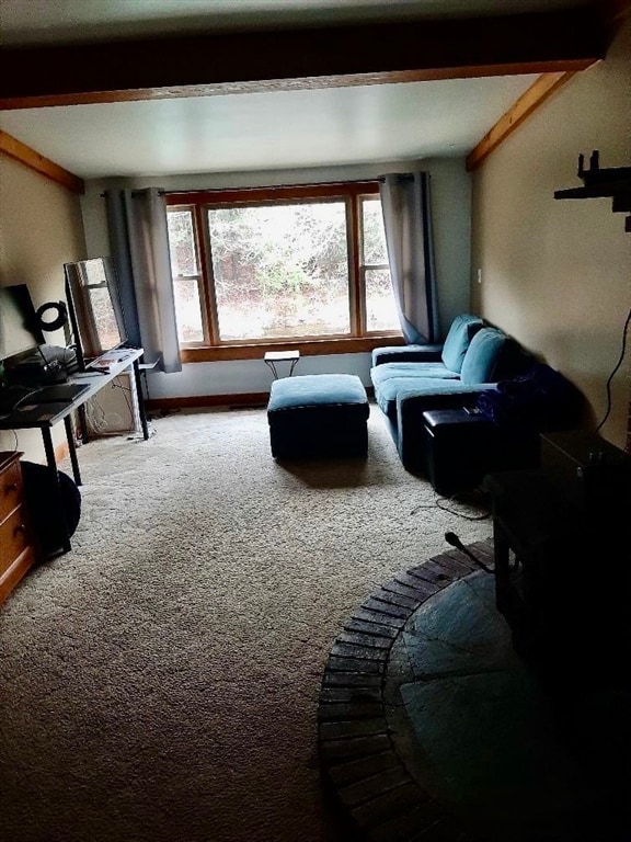 living room featuring beamed ceiling and carpet