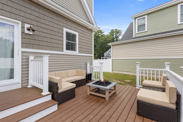 wooden deck featuring an outdoor living space with a fire pit