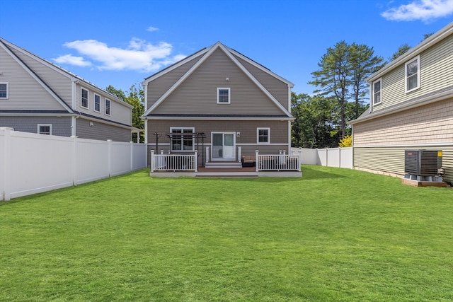 rear view of house featuring a wooden deck, a lawn, and central AC