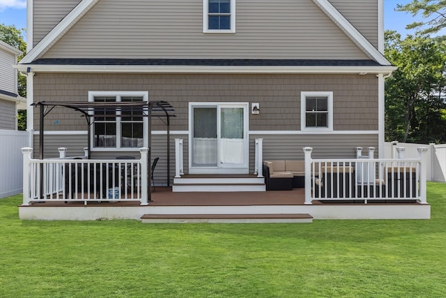 rear view of property with a wooden deck and a yard