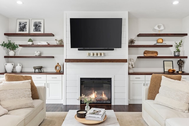 living room with light wood-type flooring and a large fireplace