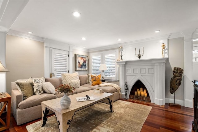 living room featuring a fireplace with flush hearth, recessed lighting, crown molding, and wood finished floors