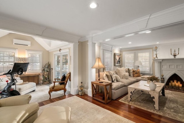 living room featuring a brick fireplace, a healthy amount of sunlight, crown molding, and a wall mounted AC