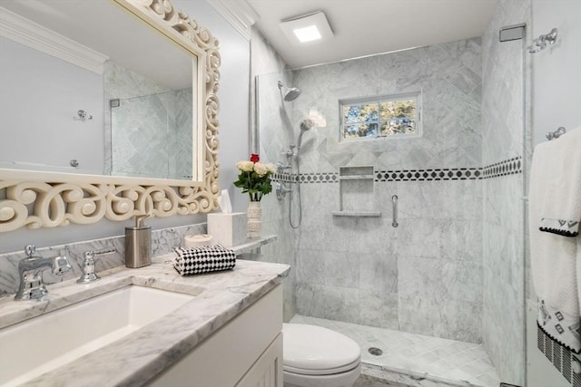 full bathroom featuring tiled shower, toilet, and vanity