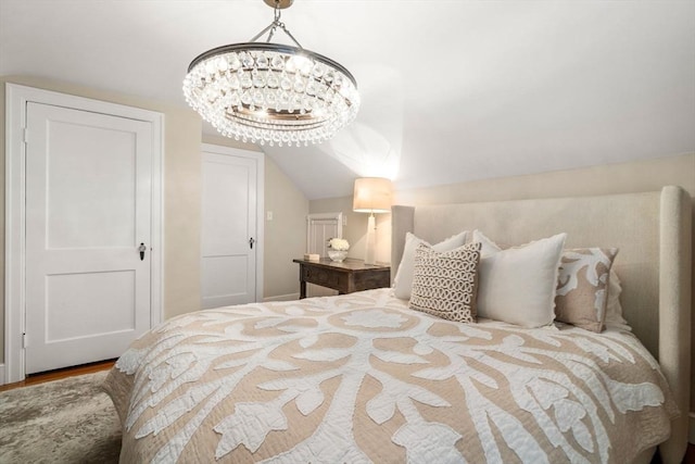 bedroom featuring lofted ceiling and a chandelier