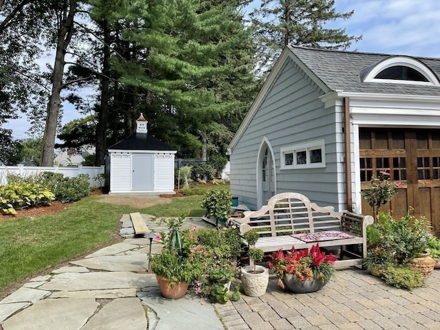 view of patio featuring an outdoor structure, fence, and a shed