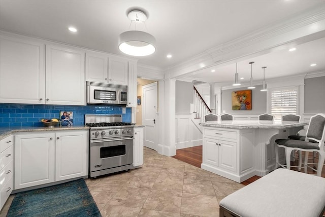 kitchen featuring stainless steel appliances, tasteful backsplash, crown molding, and white cabinetry