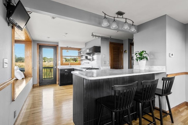 63 Seaside Rd, Scituate, MA 02066 - kitchen featuring light countertops, a breakfast bar area, light wood-style floors, and a peninsula