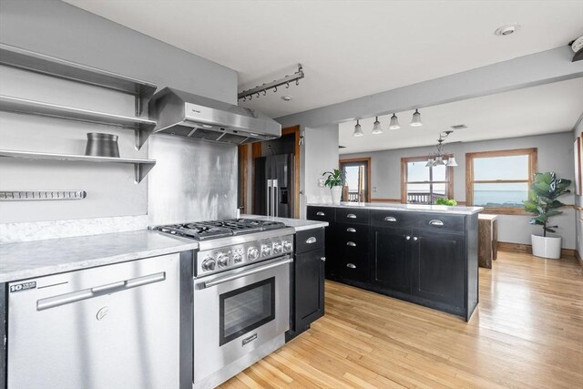 63 Seaside Rd, Scituate, MA 02066 - kitchen with high end appliances, dark cabinetry, extractor fan, light wood-style floors, and light countertops