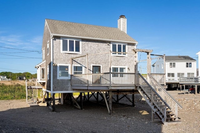 63 Seaside Rd, Scituate, MA 02066 - back of property featuring stairs, a chimney, a deck, and a shingled roof