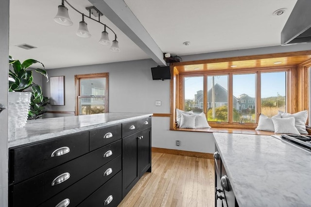 63 Seaside Rd, Scituate, MA 02066 - kitchen featuring dark cabinets, baseboards, light wood finished floors, and light stone counters