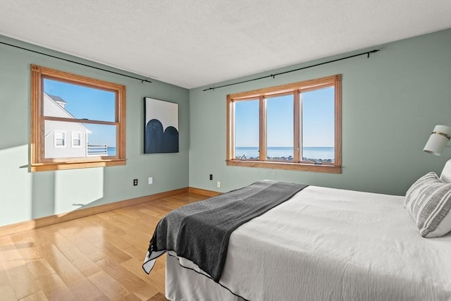 63 Seaside Rd, Scituate, MA 02066 - bedroom featuring wood finished floors, baseboards, and a textured ceiling