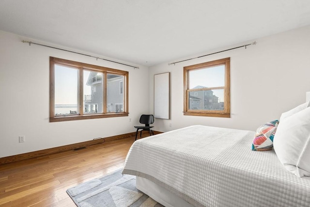 63 Seaside Rd, Scituate, MA 02066 - bedroom featuring multiple windows, light wood-type flooring, and baseboards