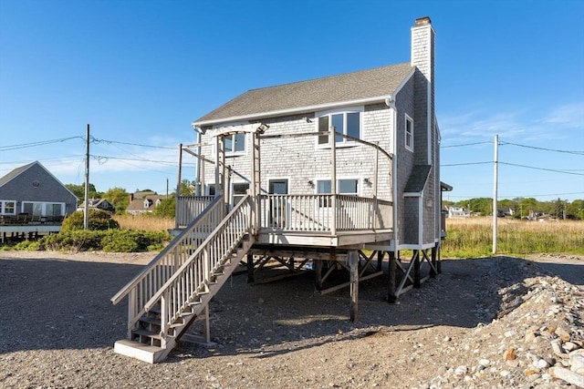 63 Seaside Rd, Scituate, MA 02066 - rear view of house with a chimney, a wooden deck, roof with shingles, and stairway