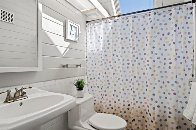 bathroom featuring a sink, visible vents, toilet, and a shower with shower curtain