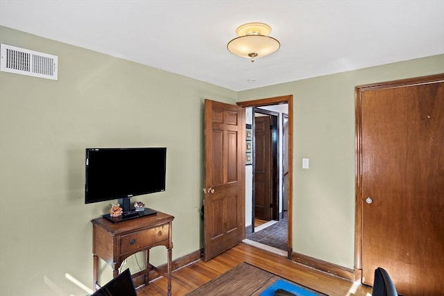 bedroom with visible vents, baseboards, and wood finished floors