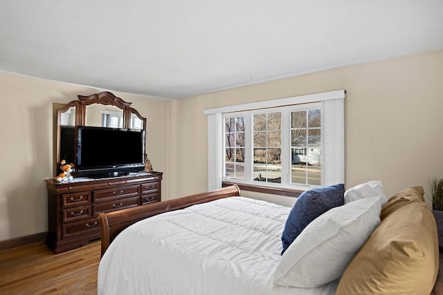 bedroom featuring baseboards and wood finished floors