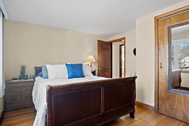 bedroom with wood finished floors and baseboards