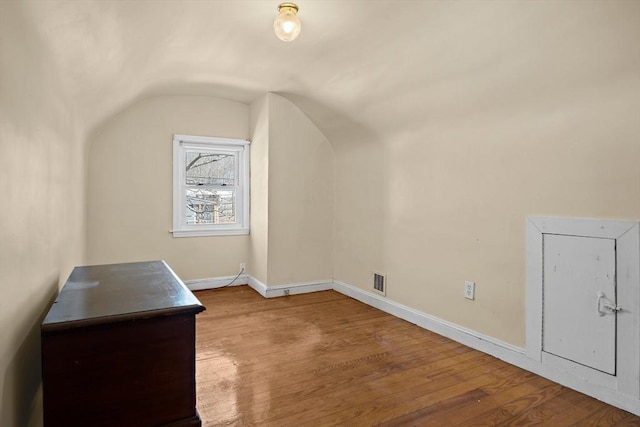 additional living space with visible vents, wood finished floors, and baseboards