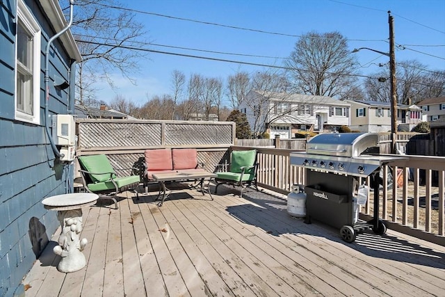 wooden deck featuring area for grilling, a residential view, and fence