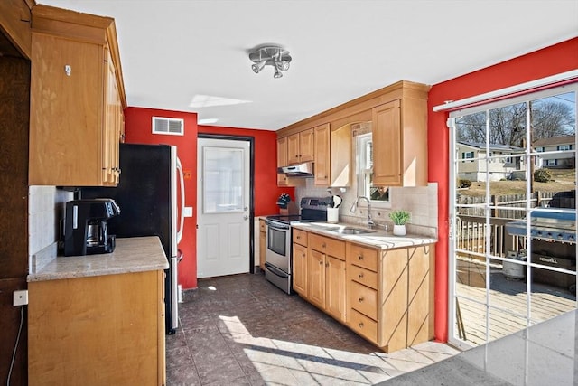 kitchen with visible vents, a sink, under cabinet range hood, backsplash, and appliances with stainless steel finishes