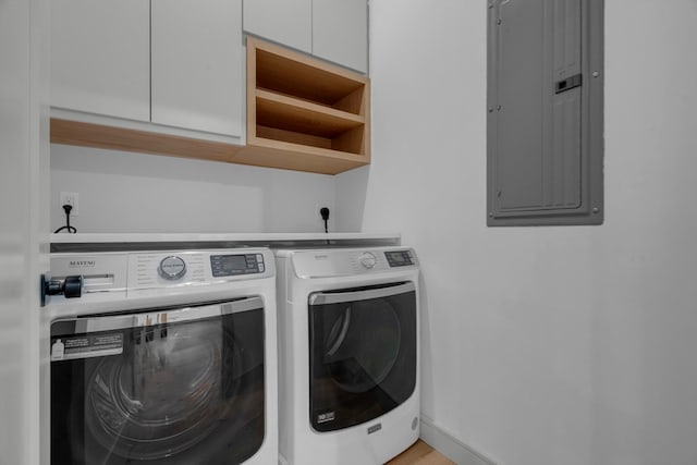 laundry area with electric panel, cabinets, and washing machine and dryer