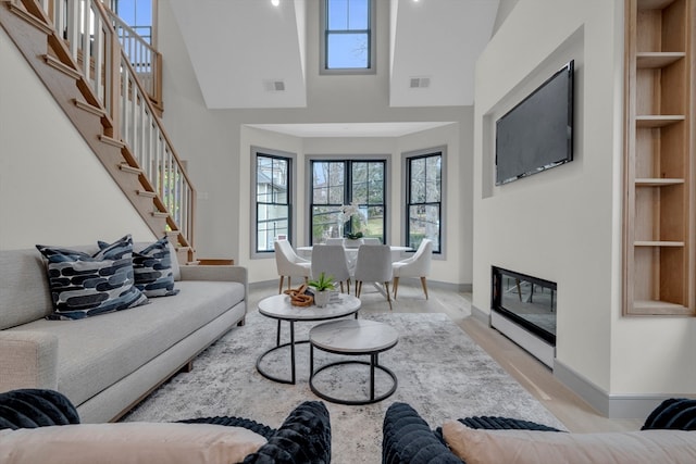 living room with built in shelves and high vaulted ceiling