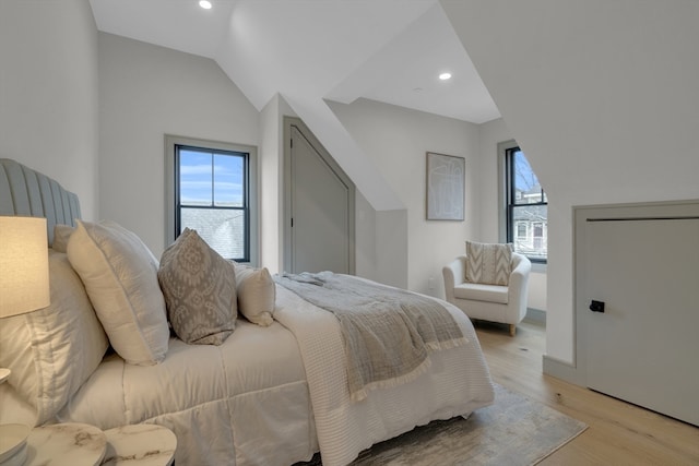 bedroom featuring light wood-type flooring and lofted ceiling